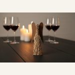 Rindenengel aus Holz auf einem Esstisch mit Weingläsern und Kerze