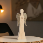 Wendeengel mit Herz aus Holz auf einem runden Holzbrett