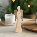 Wendeengel mit Herz aus Holz mit Kerzen im Hintergrund