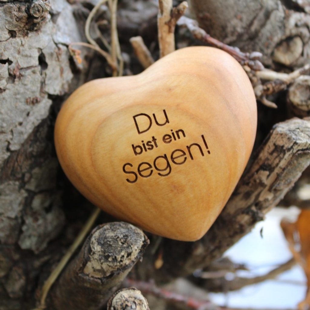 Holzherz mit Gravur „Du bist ein Segen“ auf einem Baumstamm