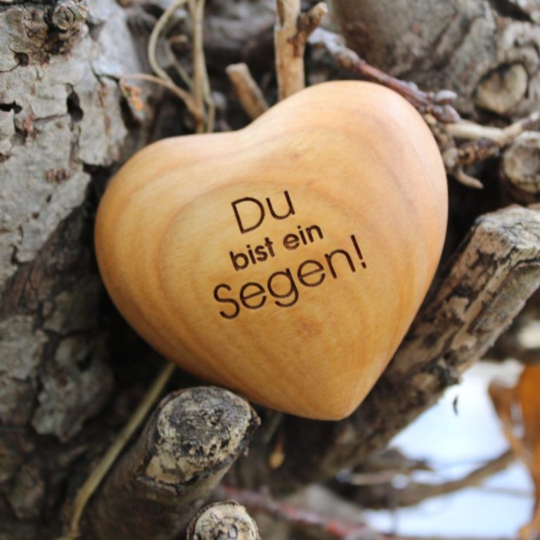 Holzherz mit Gravur „Du bist ein Segen“ auf einem Baumstamm