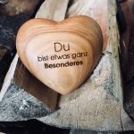 Holzherz „Du bist etwas ganz Besonderes“ auf einem Holzscheit