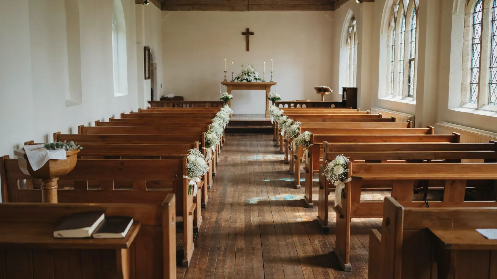 Helle Kirche mit Blumenschmuck an den Bänken und Altar (Stimmungsbild)