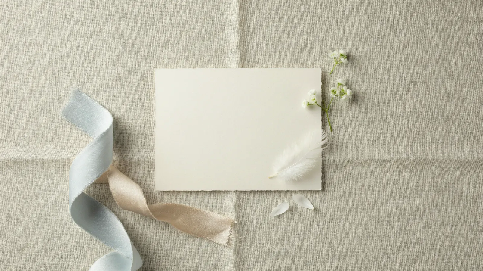 Leere Karte mit hellblauem Band und weißen Blüten (Stimmungsbild)